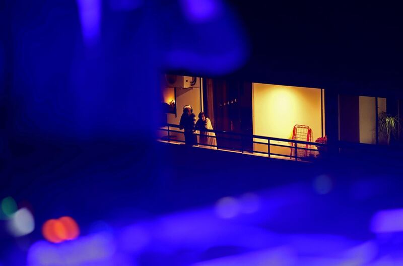 Neighbours listen to music and watch laser projections from their balconies as members of the Lebanese collective "Nuage" perform from the roof of a building to entertain confined residents on the eastern outskirts of Beirut.  AFP