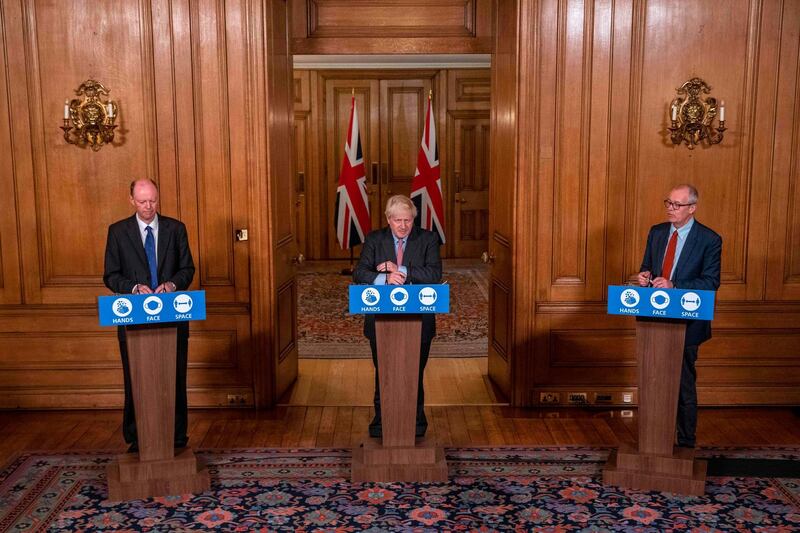 Britain's Prime Minister Boris Johnson stands alongside Britain's Chief Scientific Adviser Patrick Vallance Chief Medical Officer for England Chris Whitty. AFP