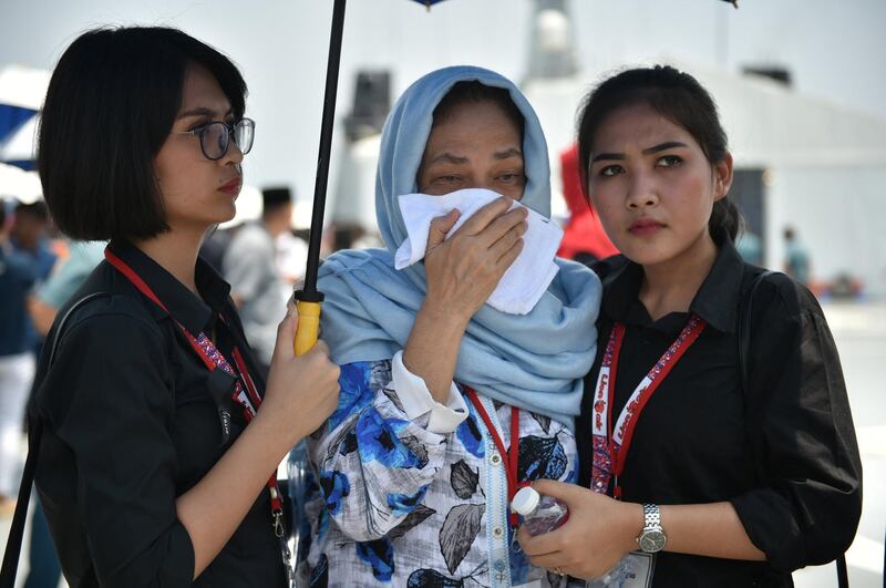 A relative (C) of a victim of the ill-fated Lion Air flight JT 610 is given assistance as she grieves during a visit to the site of the crash in the Java Sea on an Indonesian Navy vessel off the coast of Karawang in West Java on November 6, 2018. - The Indonesian Lion Air jet that plunged into the Java Sea on October 29, killing all 189 on board, had an air speed indicator problem on its fatal flight and on three previous journeys, the country's transportation watchdog said on November 6. (Photo by Bay ISMOYO / AFP)