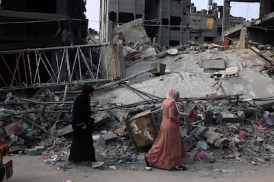 Women walk past a destroyed building in the aftermath of Israeli bombing in Rafah in the southern Gaza Strip on Saturday.  AFP