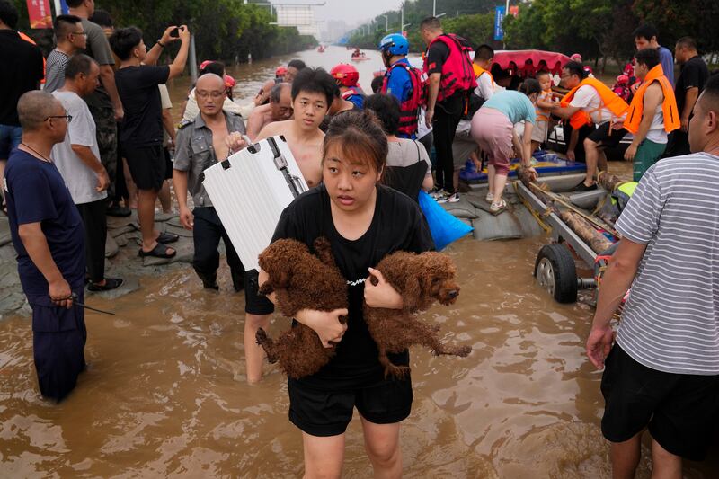 Residents evacuate their homes after flooding in Zhuozhou in northern China's Hebei province, south of Beijing, on Wednesday. AP Photo