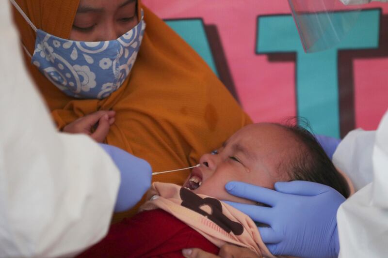 Health workers take a nasal swab sample from a girl during public testing for the new coronavirus conducted in Jakarta, Indonesia. AP Photo