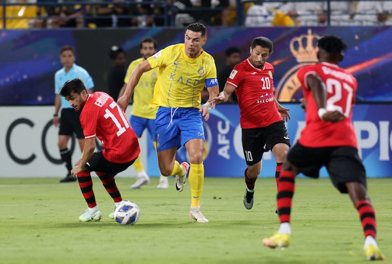 Al Nassr's Cristiano Ronaldo in action with FC Istiklol's Ehson Panshanbe and Aliser Dzhalilov. Reuters