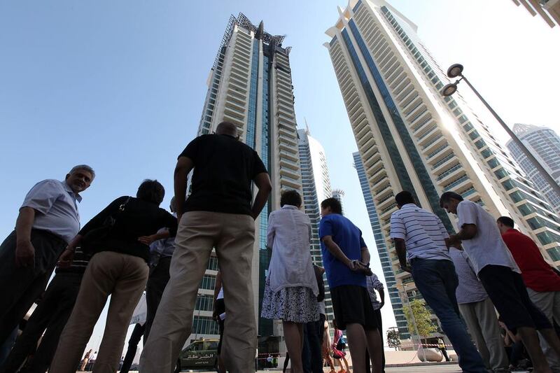 Residents wait anxiously outside Tamweel Tower, in Jumeirah Lakes Towers, after the fire that gutted the building in November 2012. Pawan Singh / The National 