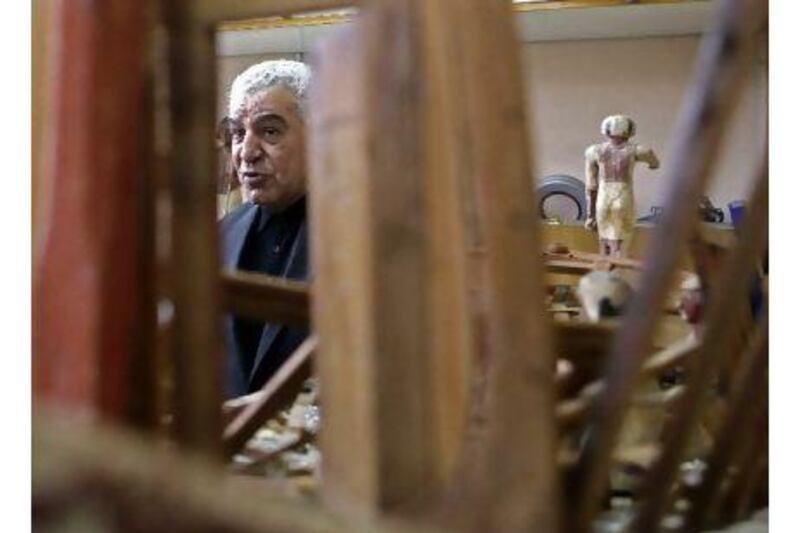 Egypt's minister of antiquities, Zahi Hawass, stands beside artifacts that were damaged in the Egyptian Museum, located near Tahrir Square, in Cairo.