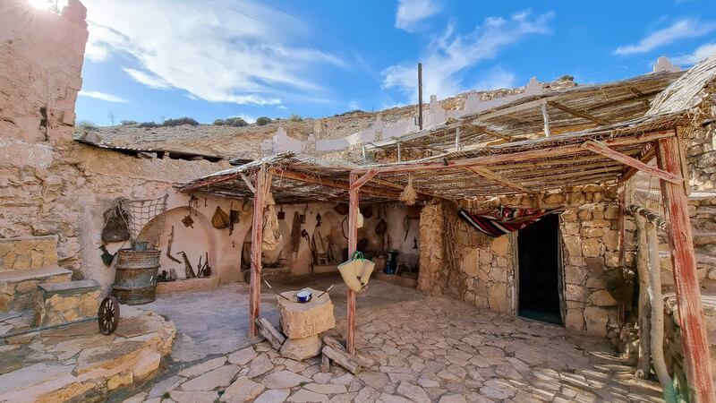 A picture shows a view of an external yard of a "damous", a dwelling carved into Libya's arid Nafusa mountains, in Gharyan town, about 100 Km southwest of the capital, on February 5, 2022.  - Gharyan's unique underground houses were hewn into the mountainside centuries ago, and many lie abandoned, but residents of the Libyan town are hoping tourism can help restore their heritage.  (Photo by Mahmud TURKIA  /  AFP)