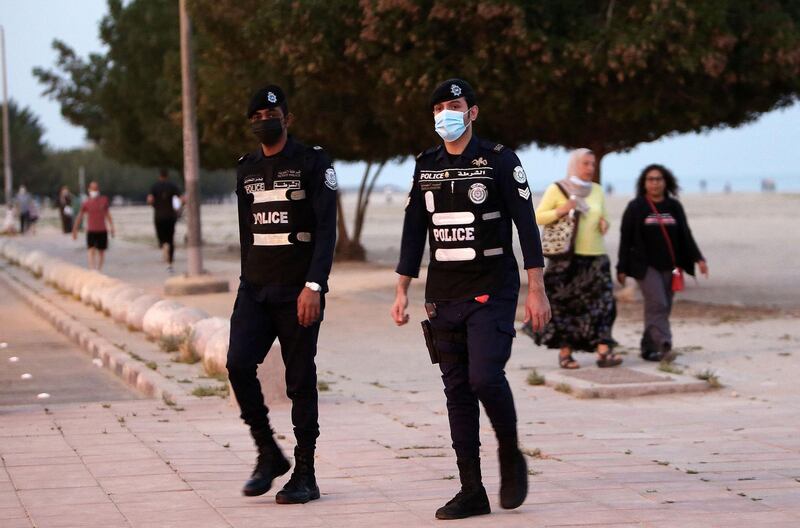 Kuwaiti policemen on patrol at a waterfront promenade in Kuwait City during nationwide restrictions due to the Covid-19 pandemic. AFP