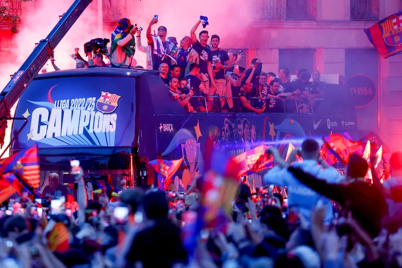 Barcelona's Robert Lewandowski, top centre, holds a scarf as he and other players celebrate from a bus during a parade to celebrate winning La Liga in Barcelona, Spain. AP Photo