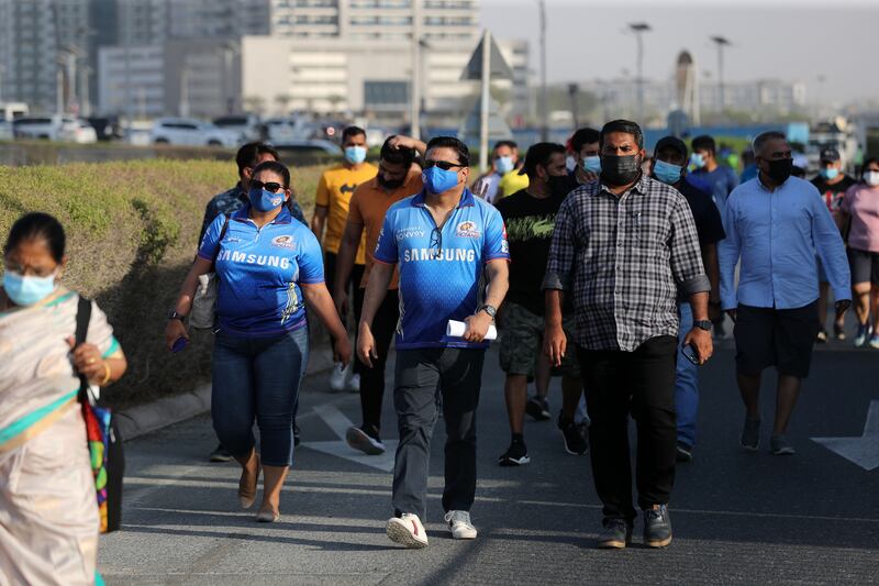 Supporters arrive at the Dubai International Stadium for the first match of the remainder of the IPL 2021 season, which is being held in the UAE. Chris Whiteoak / The National