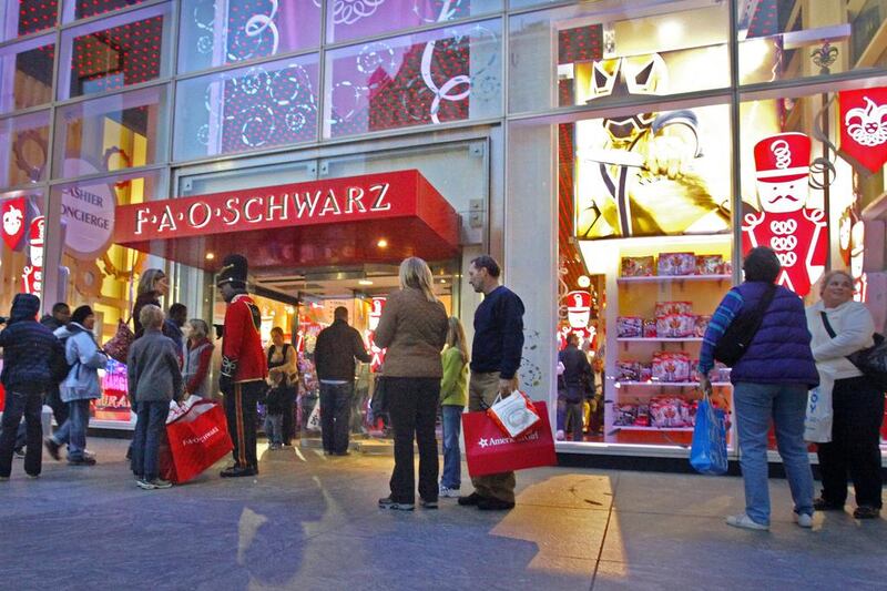 Shoppers stand outside the FAO Schwarz store in New York. Bebeto Matthews / AP Photo