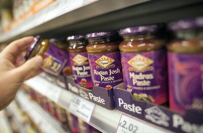 A customer selects a jar of Pataks Rogan Josh curry paste, produced by Associated British Foods Plc, from a display shelf inside supermarket in London, U.K., on Monday, Nov. 5, 2012. AB Foods shares have gained 17 percent this year, fueled by the growth of the sugar unit and Primark, the company's two main profit contributors. Photographer: Simon Dawson/Bloomberg via Getty Images