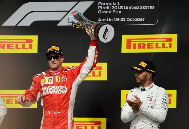 Ferrari driver Kimi Raikkonen, of Finland, holds the trophy after winning the Formula One U.S. Grand Prix auto race at the Circuit of the Americas, Sunday, Oct. 21, 2018, in Austin, Texas. Mercedes driver Lewis Hamilton, right, of Britain, finished third. (AP Photo/Eric Gay)