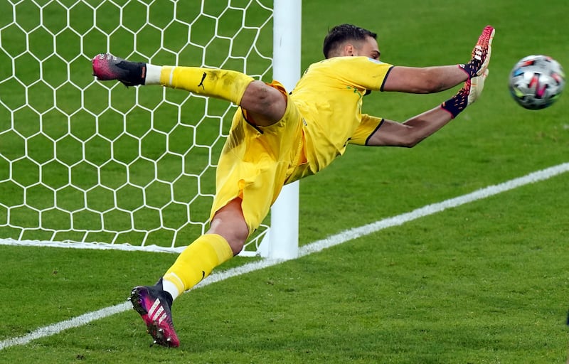 Italy goalkeeper Gianluigi Donnarumma saves from England's Jadon Sancho during the penalty shootout.