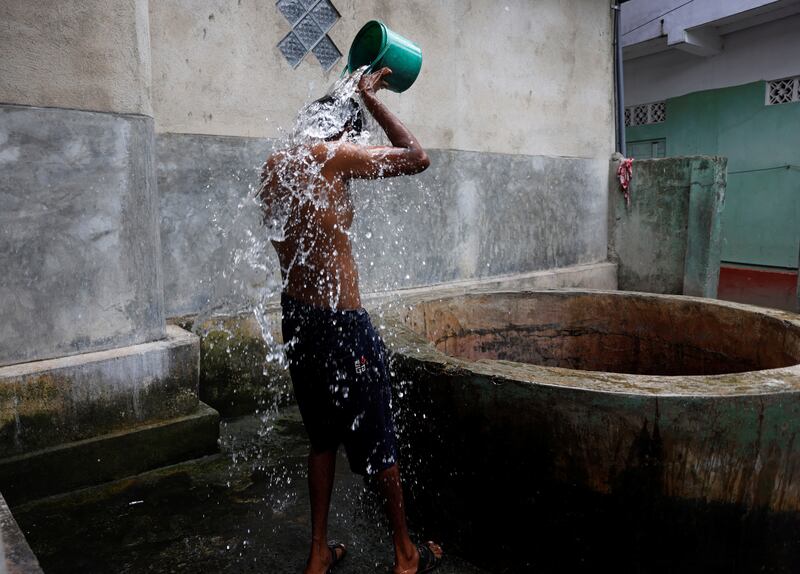 Sivaraja Sanjeewan, 31, takes a bath at a public well at Wanathamulla, Colombo.