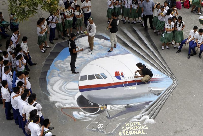 Filipino artists from the Guhit Visual Arts Group paint the image of Malaysia Airlines Flight MH370 at the Benigno Ninoy Aquino High School grounds in Makati City, south of Manila, Philippines, on March 17 to express hope and solidarity for the passengers and crew of the missing jet. Amiel Meneses / EPA