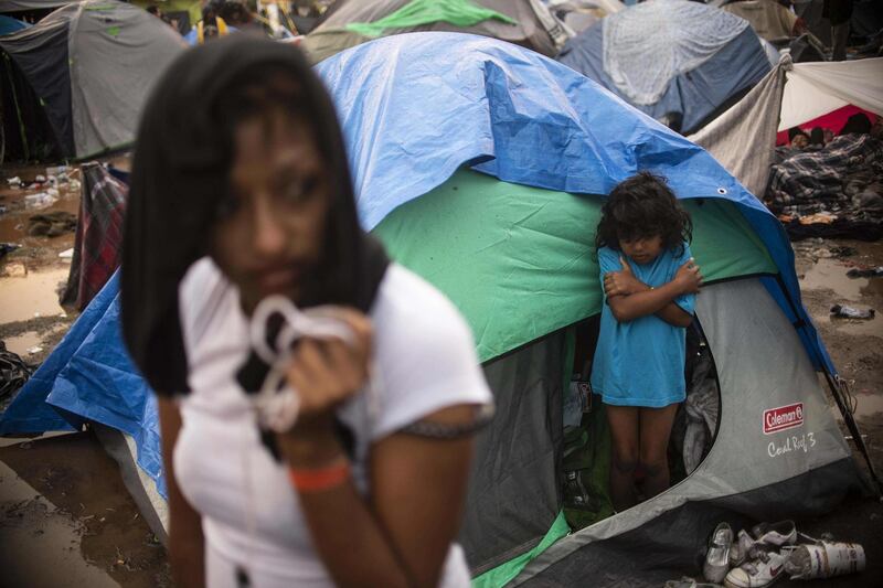 Central American migrants are seen after heavy rain. AFP