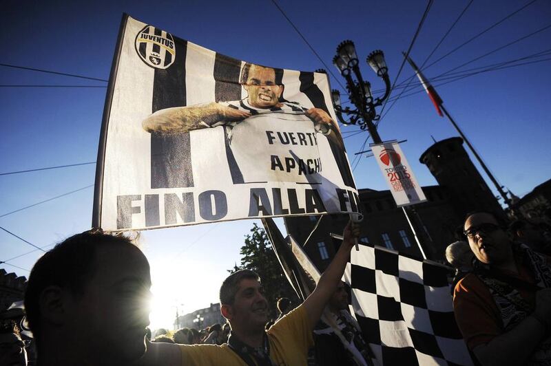 A Juventus supporter waves a flag showing player Carlos Tevez to celebrate their victory of the Serie A title on Sunday. Giorgio Perottino / Reuters / May 4, 2014