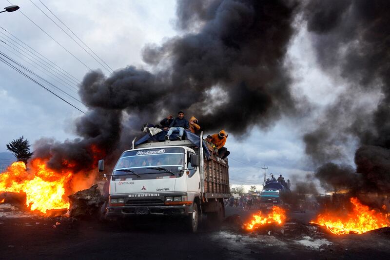 Indigenous demonstrators drive past burning roadblocks in Machachi, Ecuador, as they head towards the capital Quito, after a week of protests against President Guillermo Lasso. Reuters