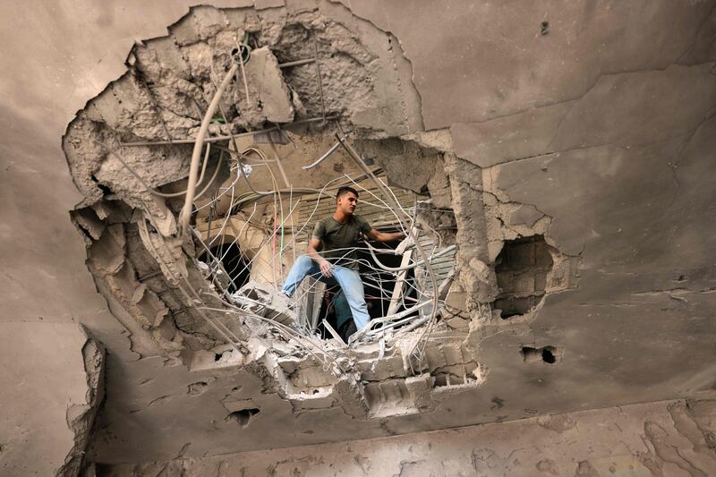 A Palestinian man checks the damage caused by an Israeli air strike at the Islamic National Bank in Khan Yunis in the southern Gaza Strip. AFP
