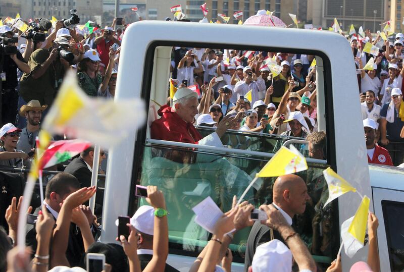 Pope Benedict XVI waves to the crowd from his popemobile as he arrives to lead an open-air mass in Beirut's waterfront on September 16, 2012, on the final day of his visit to Lebanon. Pope prayed that leaders in the Middle East work toward peace and reconciliation, in his homily at an open-air mass where an estimated 350,000 people attend. AFP PHOTO/JOSEPH EID (Photo by JOSEPH EID / AFP)