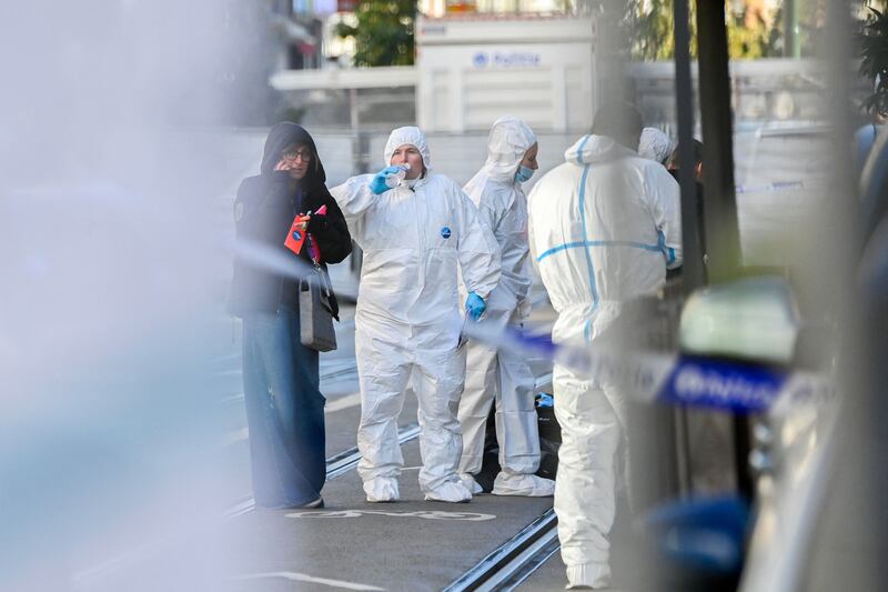Forensics officers search for evidence in the street. AFP