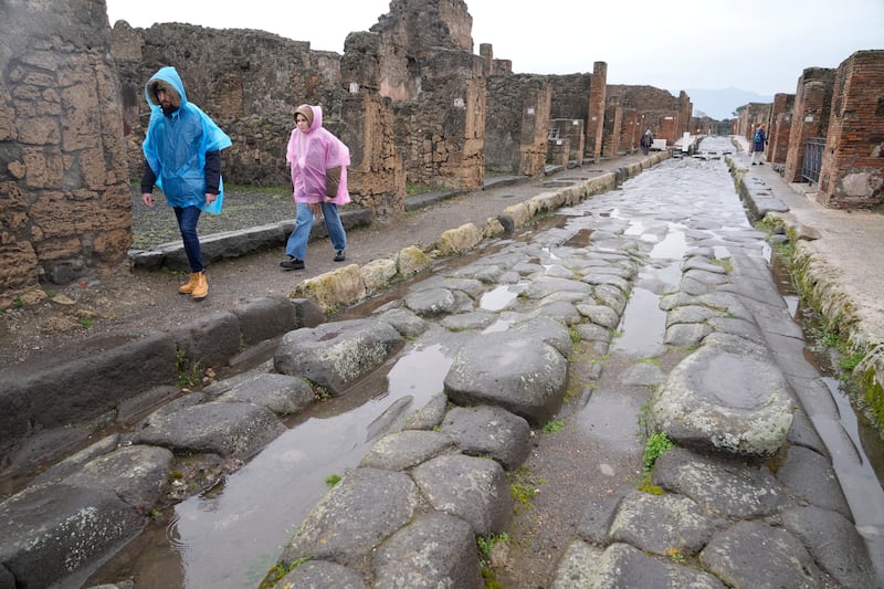 Tourists walk inside the Pompeii site.