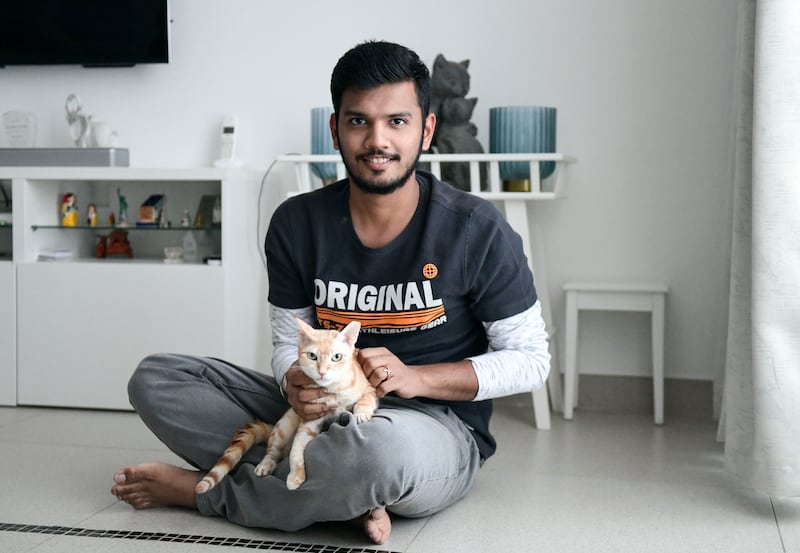Charan Ravi, brother of the pet's owner Suganya Jothilingam, with Elsa the cat. Khushnum Bhandari / The National
