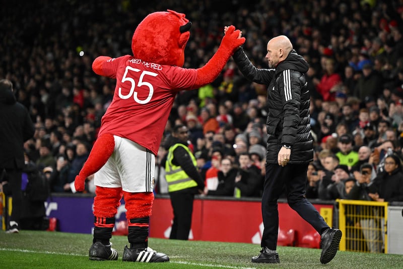 'Fred The Red' greets Manchester United's Dutch manager Erik ten Hag before the match. AFP