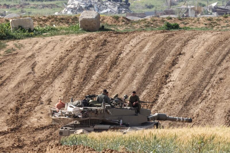 Israeli soldiers sit on top of a tank along the border with Gaza. AFP