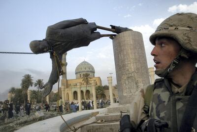 A U.S. soldier watches as a statue of Iraq's President Saddam Hussein falls in central Baghdad in this April 9, 2003 file photo. REUTERS/Goran Tomasevic  AS/CRB