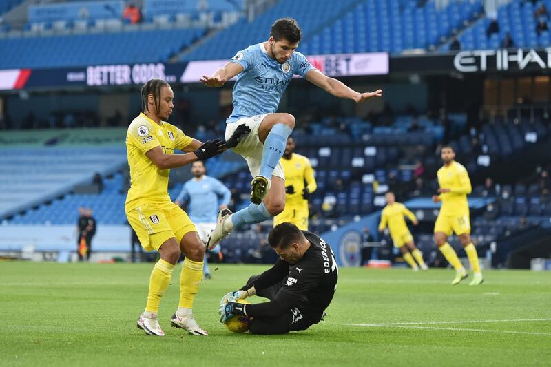 Manchester City goalkeeper Ederson claims the ball ahead of teammate Ruben Dias and Fulham's Bobby Decordova-Reid. Reuters