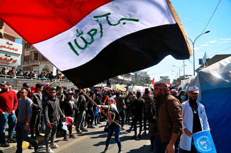 A woman waves an Iraqi flag during a protest in Tahrir Square, Baghdad, Iraq. AP Photo