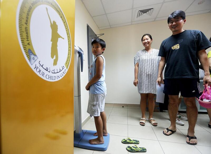 Jinpyo Hong, 8, checks his weight as part of this year's Your Weight in Gold competition.  Satish Kumar / The National