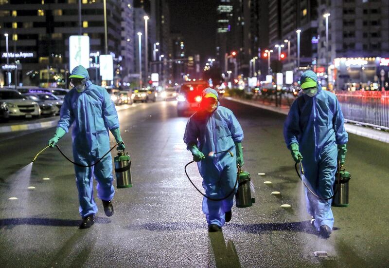 Abu Dhabi, United Arab Emirates, March 27, 2020.   
  Sanitation workers from Tadweer spraying the pedestrian crossing on Hamdan and Fatima Bint Mubarak Street.  Emiratis and residents across the UAE must stay home this weekend while a nationwide cleaning and sterilisation drive is carried out.
Victor Besa / The National
Section:  NA
Reporter:  Haneen Dajani
