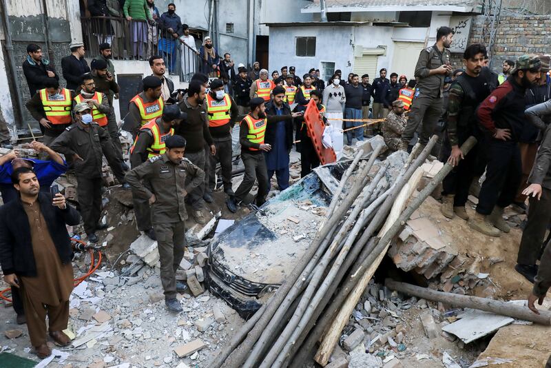 Residents and rescue workers gather amid the rubble of the mosque after the suicide blast in Peshawar. Reuters