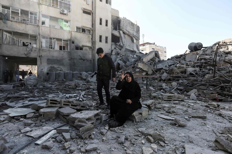 A Palestinian woman sitting next to the rubble of a building in Gaza City. AFP