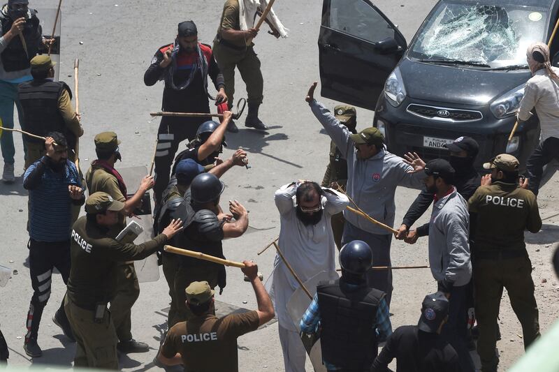 Policemen wield batons in Lahore. AFP
