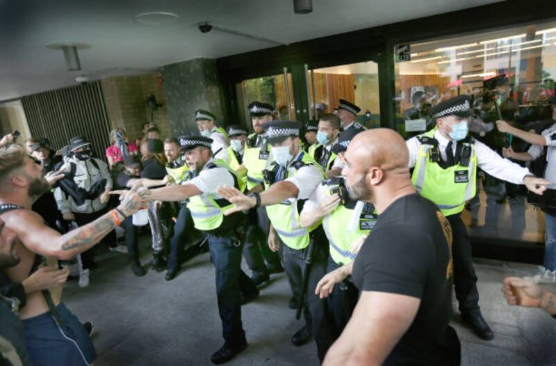 Police officers stop protesters from entering the former BBC headquarters during the demonstration against the broadcaster and pandemic measures. Getty