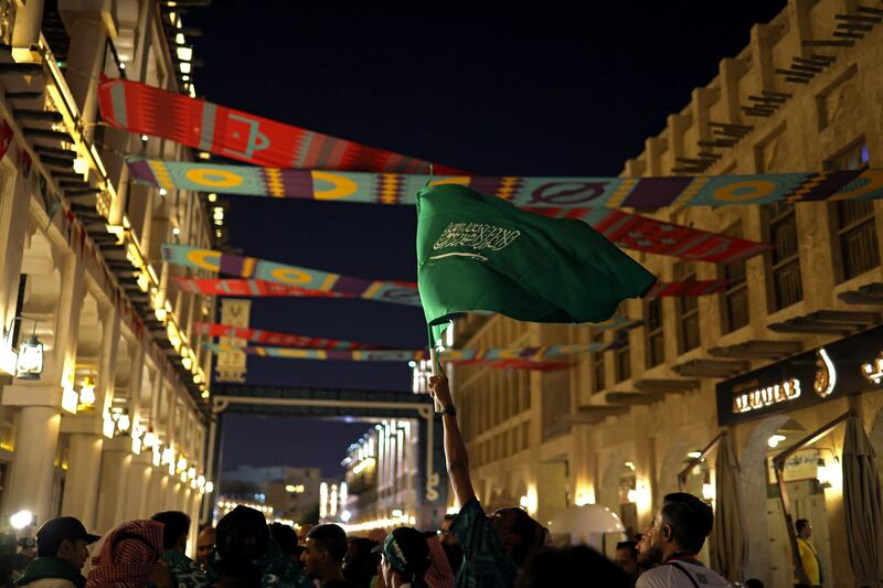 A Saudi Arabia flag is waved by a fan in Doha's Souq Waqif as the World Cup gets under way. Getty