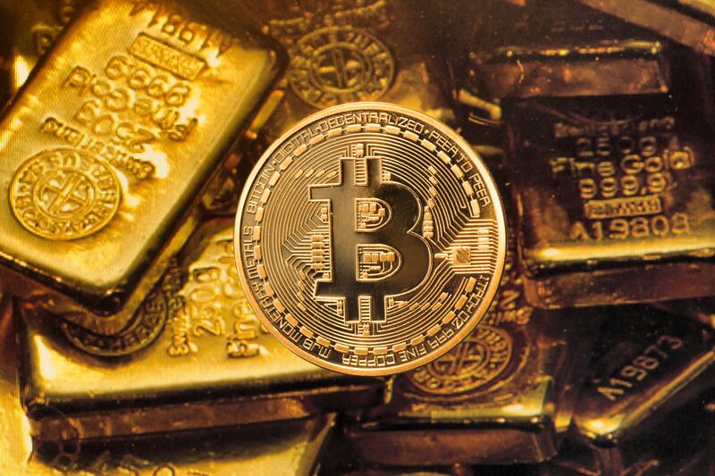 GERMANY, BONN - MAY 22: Real money or digital crooks money? The photo shows a Bitcoin (physically) with gold bars. (Photo by Ulrich Baumgarten via Getty Images)