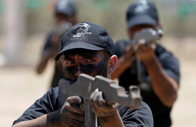 A young Palestinian aims a wooden rifle during a military-style exercise at a Hamas-run summer camp in Gaza City.  Reuters