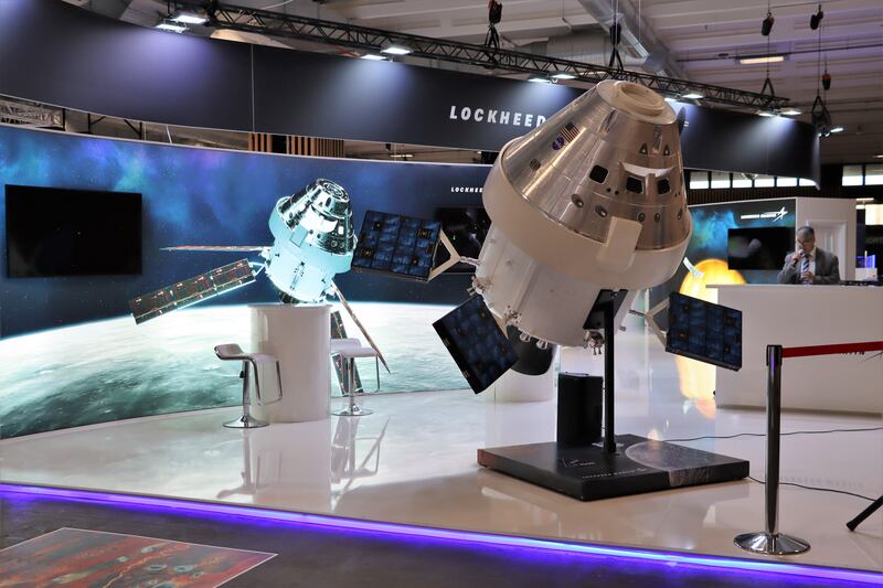 The Lockheed Martin stand at IAC 2022 in Paris displays satellites.