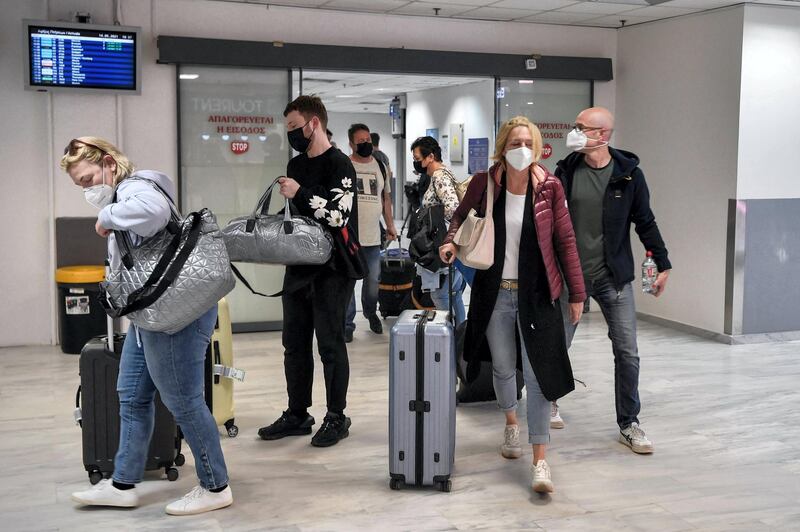 Tourists leave the international airport of Heraklion upon their arrival to spend their holidays on the island of Crete on May 14, 2021. 2021.  Greece kickstarts its tourism season on May 14, 2021, with both the government and travel operators hoping the lure of sun, sand and sea will bring a sorely needed revenue boost after last year's miserable holiday season amid the covid-19 pandemic. / AFP / Louisa GOULIAMAKI
