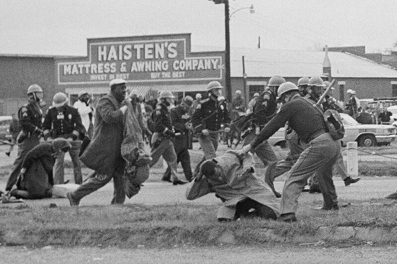 A state trooper swings a billy club at John Lewis, right foreground, chairman of the Student Nonviolent Coordinating Committee, to break up a civil rights voting march in Selma, Alabama on March 7, 1965.  AP Photo