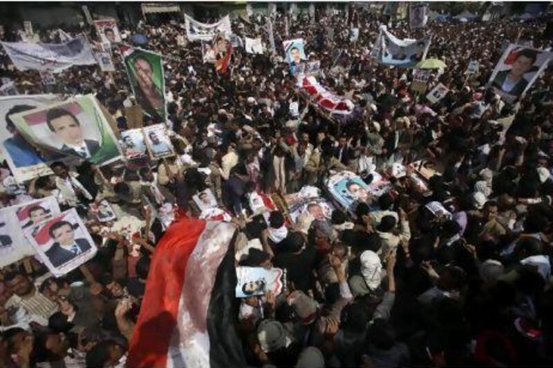 People gather by the bodies of the demonstrators killed on Friday, during a funeral procession in Sana'a yesterday.