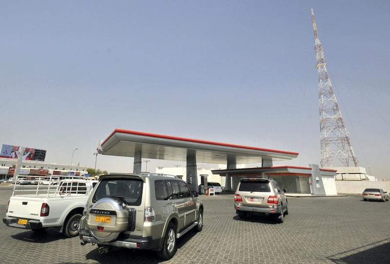 Cars line up at a petrol station in Al Buraimi, near Oman's border with the United Arab Emirates September 14, 2010. Gasoline price hikes in the United Arab Emirates have boosted sales in neighbouring Oman this year as motorists cross the border to fill up on cheaper fuel, and some have begun to resell it to UAE firms. UAE gasoline prices have risen 26 percent since April, when the government introduced the first of two price hikes imposed so far. Neighbouring Oman has kept its fuel subsidies unchanged.
 This station has experienced an increase of up to fifty percent in sales since the rise in fuel prices in the UAE, according to the owner. Picture taken September 14, 2010. REUTERS/Jumana El-Heloueh (OMAN - Tags: TRANSPORT BUSINESS)