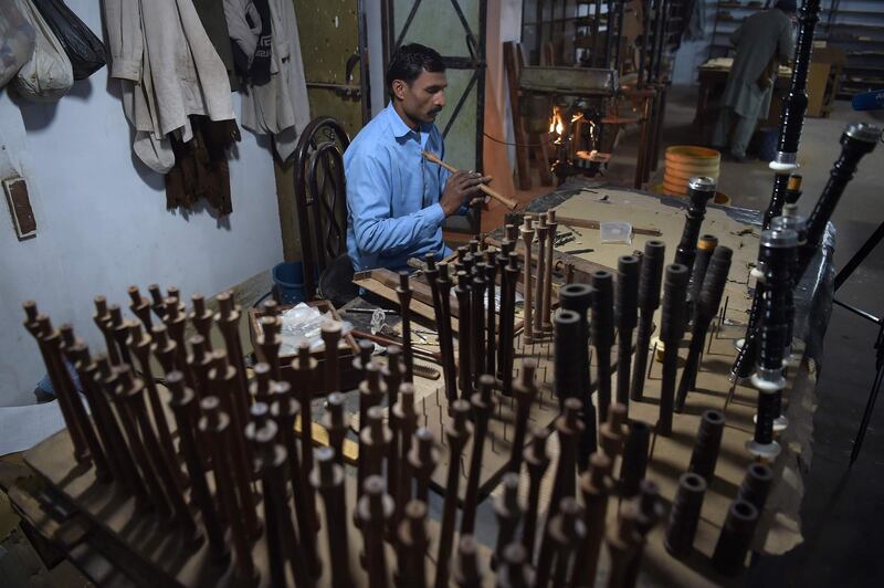 A Pakistani worker making bagpipes at the Mid East bagpipe factory. AFP.