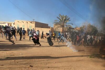 FILE PHOTO: Sudanese demonstrators run from a teargas canister fired by riot policemen to disperse them as they participate in anti-government protests in Omdurman, Khartoum, Sudan January 20, 2019. REUTERS/Mohamed Nureldin Abdallah/File Photo