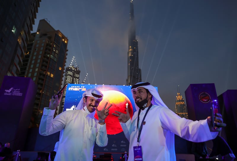 Emirati men pose as they attend an event to mark the Hope Probe's entering the orbit of Mars, near Burj Khalifa, in Dubai, United Arab Emirates, February 9, 2021. REUTERS/Christopher Pike