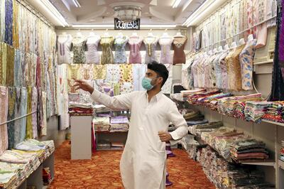 RAK , UNITED ARAB EMIRATES , May 13 – 2020 :-  Imran Khan from Pakistan working at the Zahrat Al Banafsaj garments shop at the Kuwaiti shopping street in Ras Al Khaimah. (Pawan Singh / The National) For News/Online. Story by Ruba Haza